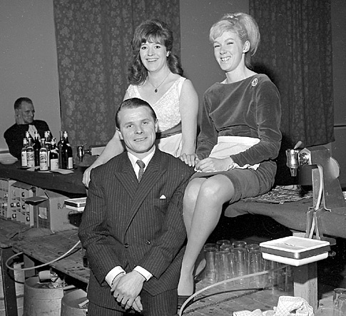 February 1966: The landlord of the Fountain Inn, Morley, and two of his barmaids at a function at Morley Town Hall.